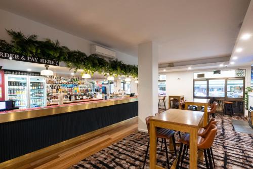 a restaurant with a bar with a table and chairs at Royal Hotel in Tumut