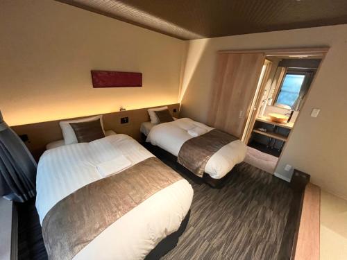 a hotel room with two beds and a window at Guest One More Heart at Higashi Otowa in Gionmachi