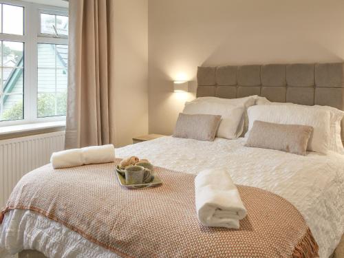 a bedroom with a bed with towels on it at Willow Cottage in Conwy