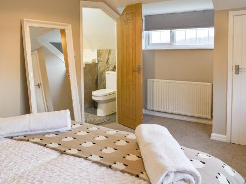 a bedroom with a bed and a bathroom at Willow Cottage in Conwy
