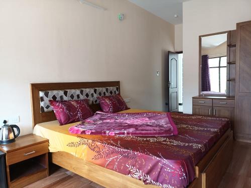 a bedroom with a large bed with purple sheets at Karpagam Residency in Ooty
