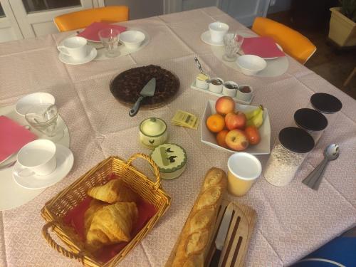 een tafel met brood en fruit erop bij La Petite Maison in Givry