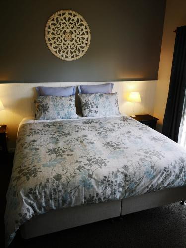 a bedroom with a bed with a blue and white comforter at Hilltop Haven in Tinopai