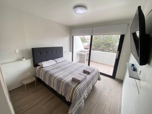 um quarto com uma cama e uma grande janela em Deluxe Apartments in Arequipa Downtown em Arequipa