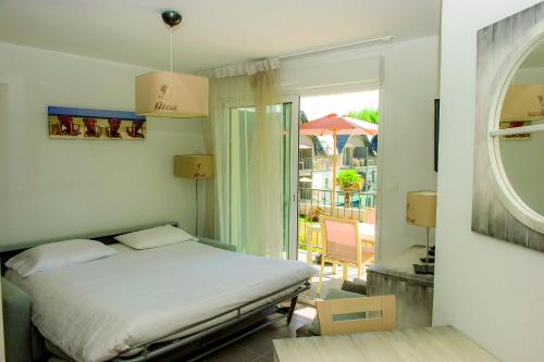 a bedroom with a bed and a view of a balcony at Résidence Vacances Bleues Les Jardins d'Arvor in Bénodet