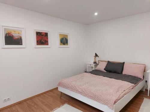 a white bedroom with a bed and some pictures on the wall at Kesklinna peatuspaik in Tallinn