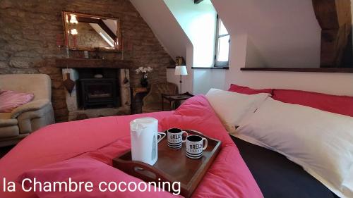 - un lit avec un plateau avec deux tasses dans l'établissement Chambre cocooning, à Malguénac