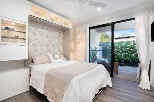 a bedroom with a bed and a large window at Luxury Golf Stay and Play in Peregian Springs