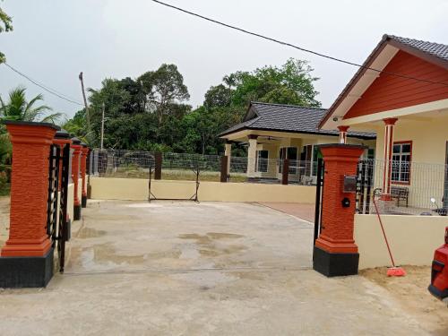 eine Reihe orangefarbener Säulen vor einem Gebäude in der Unterkunft Adilah Homestay B in Pasir Puteh