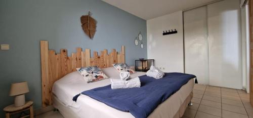 een slaapkamer met een bed met een houten hoofdeinde bij Le Victoria, vue mer et montagne in Saint-Pierre