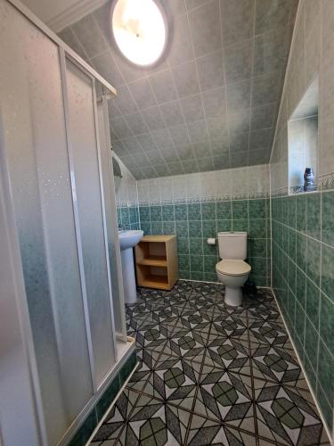La salle de bains est pourvue de toilettes et d'un lavabo. dans l'établissement Pensjonat ,,Eden'', à Degendorf