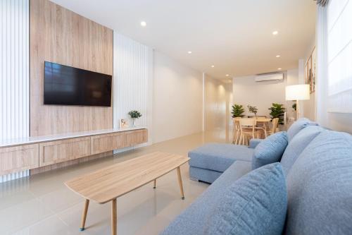 a living room with a blue couch and a table at 2BR Homey townhome 350M walk to Kata Beach Fully equipped in Kata Beach