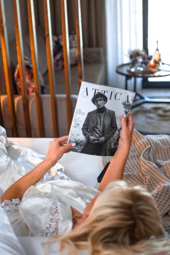 a woman laying on a bed reading a magazine at Live The Luxe in Kallithea Halkidikis