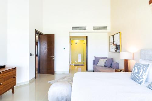 a white bedroom with a bed and a couch at Mareazul Beach Front Condos At playa del Carmen in Playa del Carmen