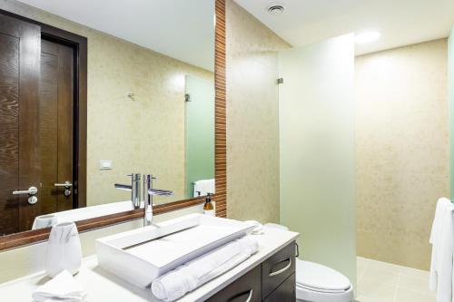 a bathroom with a sink and a toilet and a mirror at Mareazul Beach Front Condos At playa del Carmen in Playa del Carmen