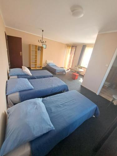 a group of four beds in a room at Pensjonat ,,Eden'' in Charbrowo