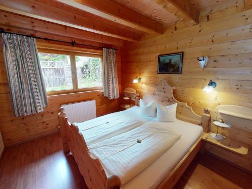 a bedroom with a bed in a log cabin at Chalet in Wildkogel near Ski Slopes & Pool in Neukirchen am Großvenediger