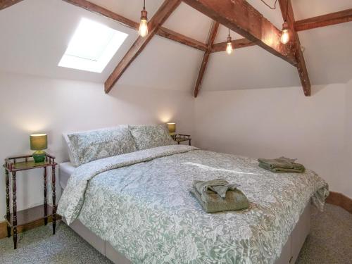 a bedroom with a bed in a room with beams at Daffodils in Coanwood