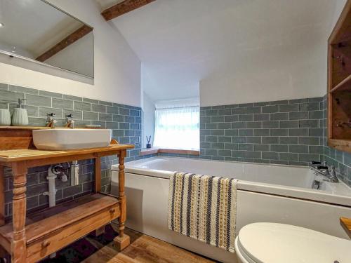 a bathroom with a tub and a sink and a toilet at Daffodils in Coanwood