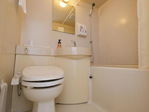 a white bathroom with a toilet and a sink at Fukuyama Oriental Hotel in Fukuyama
