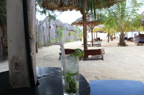 a drink sitting on a table on the beach at Mocco Beach Villa in Kendwa