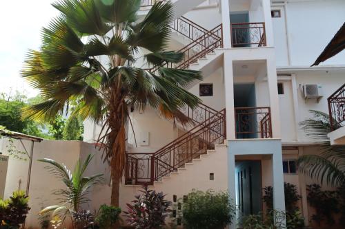 a building with stairs and a palm tree in front of it at Mocco Beach Villa in Kendwa