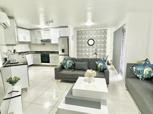 a living room with a couch and a table at Stunning 2 Bed - Rooftop Braai Area - Sunset Views in Durban