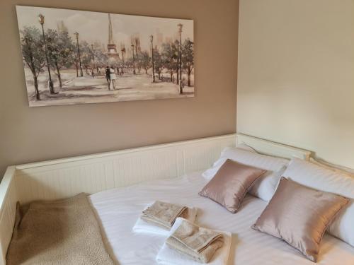 łóżko z dwoma poduszkami i obrazem na ścianie w obiekcie CeCe's w mieście Gurnard
