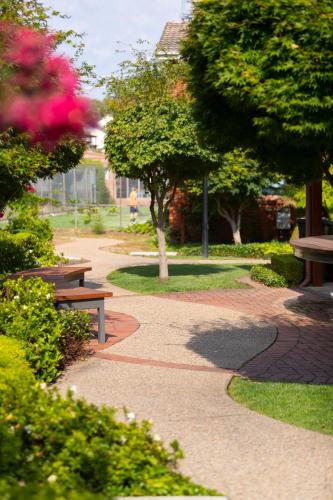 a park with benches and trees on a sidewalk at Forrest Hotel & Apartments in Canberra