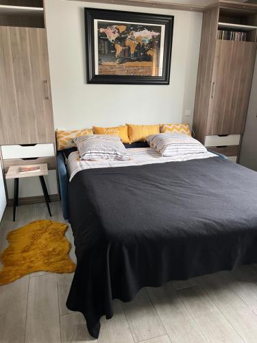 a bedroom with a large bed with a black blanket at La fleur des marais in Batz-sur-Mer