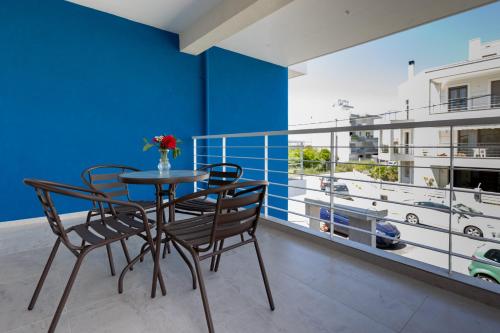 comedor con mesa y sillas en el balcón en Pagani Blue - Luxury Maisonette A1, en Kalamata