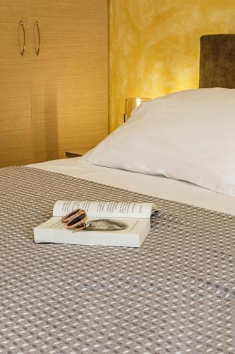 a book with a pair of scissors on a bed at Savvas Apartment in Tolo