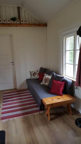 a living room with a blue couch and a wooden table at Rosa's stuga in Tasebo