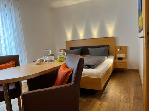 a bedroom with a bed and a table with a desk at Gästehaus am Bodensee in Immenstaad am Bodensee