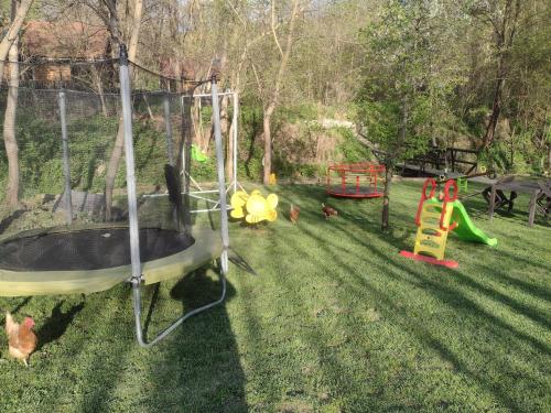 a yard with a playground with chickens in the grass at Garmen Hills Guest Houses in Garmen