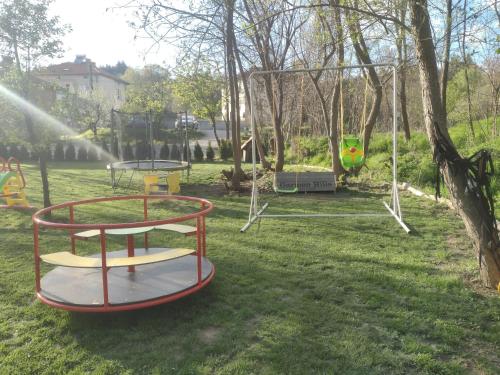 a park with two swings and a trampoline at Garmen Hills Guest Houses in Garmen