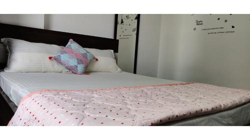 a bed with a comforter and two pillows on it at Anyhour Stay in Gannavaram
