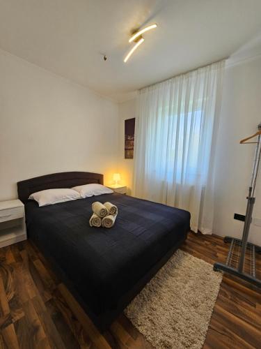 - une chambre avec un grand lit noir et une fenêtre dans l'établissement Vila KRISTINA, à Nedeščina