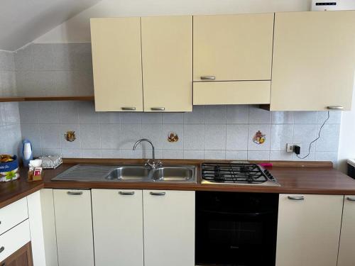 a kitchen with white cabinets and a sink at Casa di Maria in Diamante