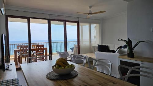 una sala de estar con una mesa con un bol de fruta en Súper Mar Azul en Salou, en Salou