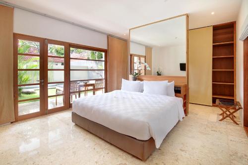 a bedroom with a large bed and a large mirror at Uma Sapna Seminyak in Seminyak