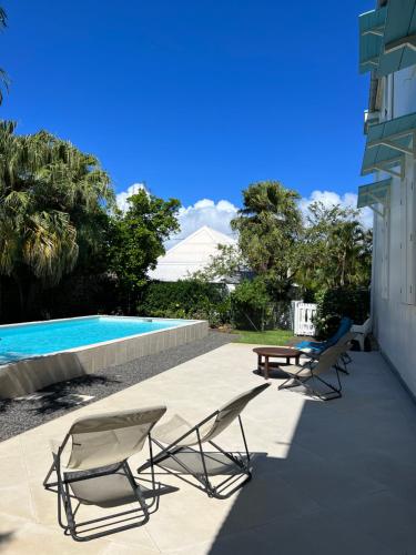 two chairs and a table and a swimming pool at Villa Myriam in Saint-Pierre