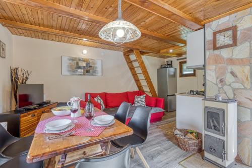 a kitchen and dining room with a table and chairs at Rozi's Riverside Cottage - Happy Rentals in Osilnica