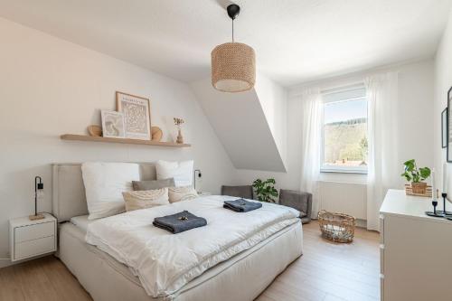 ein Schlafzimmer mit einem großen weißen Bett in einem Zimmer in der Unterkunft Premium Apartment - Ausblick - Kamin - Balkon - Smart TV - Kaffeevollautomat in Wernigerode