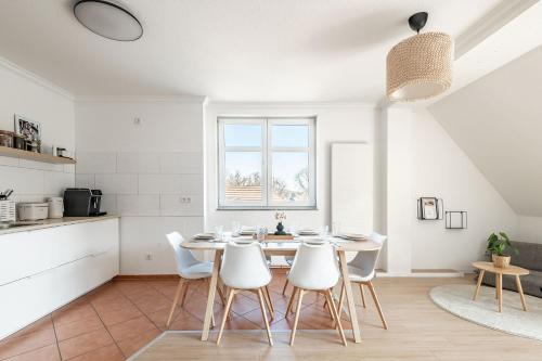 eine Küche und ein Esszimmer mit einem Tisch und Stühlen in der Unterkunft Premium Apartment - Ausblick - Kamin - Balkon - Smart TV - Kaffeevollautomat in Wernigerode