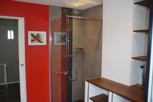 La salle de bains est pourvue d'une douche avec une porte rouge. dans l'établissement 3 pièces dans le ciel, à Gattières