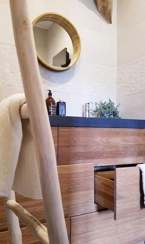 une chaise dans une pièce avec un miroir mural dans l'établissement L'Annexe du Moulin Renaudiots, à Autun