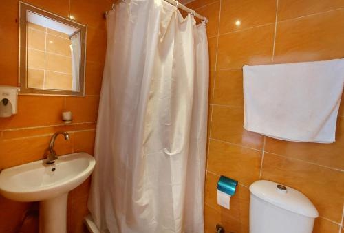 a bathroom with a white shower curtain and a sink at Travelers House in Cairo