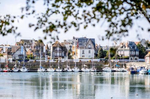 a group of boats are docked in a harbor at La maison Baz in Deauville