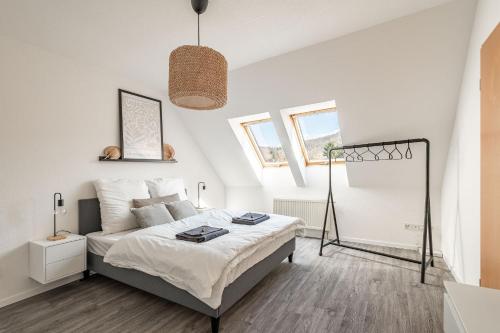 Habitación blanca con cama y ventana en Modernes Apartment am Campus - Parken - Smart-TV - Kaffeevollautomat, en Wernigerode